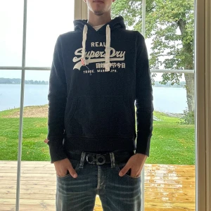 Superdry Hoodie - Svart Superdry hoodie i mycket bra skick | Storlek: XS-S | Jag är 182cm och väger 65kg📏| Vid frågor eller diskussion om pris är det bara att skriva ✍🏼 | Frakt inom 48h📦