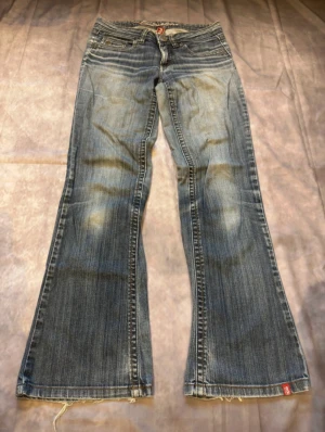 Blå bootcut, flared jeans - Snygga blå bootcut jeans från Lucky Brand med klassisk femficksdesign och slitna detaljer vid benslut. Jeansen har låg midja och är tillverkade i mjukt denim med ljusa tvättade partier för en cool vintagekänsla. Perfekt passform och bredare ben. måtten finns på bilderna😽