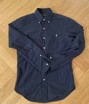 Mörkblå Ralph Lauren skjorta  - Snygg mörkblå skjorta från Ralph Lauren med klassisk krage och vita knappar. 