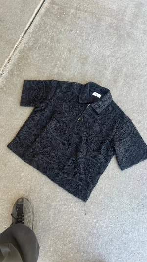 Dreamz| Svart broderat skjorta  -  Paisley-inspirerat broderat spetsmönster. Materialet är bomull och ger en cool, unik vibe med sin detaljerade struktur och loose passform. Storlekar finns från | XS- XXL| skriv gärna om din längd och vikt för en precis storlekar för just din kropp! Org pris 499