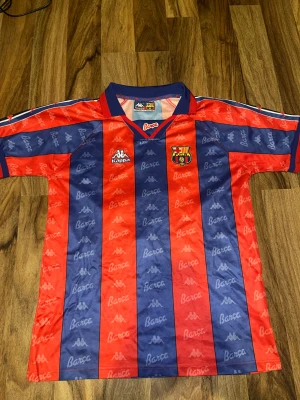 Barcelona hemmaställ 1992-1995 - FC Barcelona hemmatröja ifrån 1992-1995 Med den brasilianske Ronaldo (R9) på ryggen. Tröjan är i supportervarianten och i mycket fint skick. Storlek S.