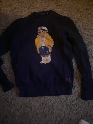 Mörkblå stickad tröja Polo Bear - Säljer en mörkblå stickad tröja från Polo Ralph Lauren, Sparsamt använd, storlek S