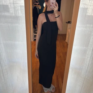 Svart långklänning med scarf - Svart långklänning med tillhörande scarf. Helt ny med prislapp, nypris 569kr. Storlek 36. 