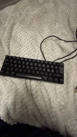 Kompakt USB-tangentbord - Smidigt och kompakt USB-tangentbord med nordisk layout. Perfekt för både arbete och spel, ansluts enkelt via USB. Tangenterna ser hela ut och kabeln är i gott skick. Inga synliga defekter eller slitage. Passar till både stationära och bärbara datorer.