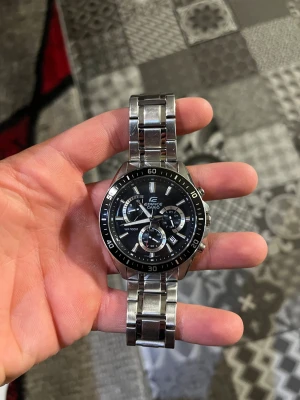 Casio Edifice kronograf herrklocka - Snygg Casio Edifice kronograf med svart urtavla och silverfärgat armband i rostfritt stål. Klockan har flera subdials, markerad bezel och robust länkarmband. Perfekt för dig som gillar sportig och stilren design med tekniska detaljer.