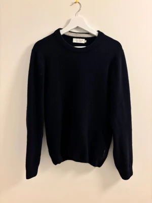 Mörkblå stickad tröja Casual Friday S - Mörkblå stickad tröja från Casual Friday i storlek S. Tröjan har rund hals, ribbade muddar vid ärmslut och nederkant samt långärmad passform. Perfekt för dig som gillar enkel och stilren design med mjukt material. Knappt använd, Nypris:800kr