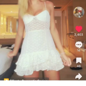 Vit kort klänning med volang - Supersöt vit kort klänning med broderade hål och volangkant. Hade denna på kvällen på studenten!! Storlek S!