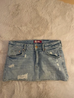 Snygg jeans kjol med slitningar!! - Jätte cool jeans kjol som är köpt på vinted och sparsamt använd av mig, super fint skick. Älskar den men den har tyvärr blivit för liten för mig nu. Storleken sitter lite tajt på mig som brukar ha S så skulle säga att den passar nån som har storlek Xs. Midjemåttet är 41cm och längden är 30cm!!😊😊🫶🏻