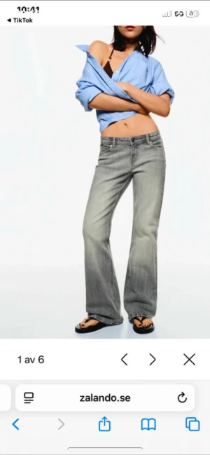 Gråa wide jeans med låg midja - Snygga grå jeans med tvättad look och låg midja. Modellen har raka, vida ben och klassiska femficksdetaljer. Perfekta för en avslappnad och trendig stil. Jeansen är tillverkade i denim och har bälteshällor samt dragkedjegylf.