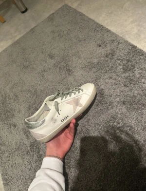 Golden Goose  - Golden Goose sneakers i vitt skinn med grå snörning och silverdetalj på hälen. Sidan har en ljusgrå mockastjärna. og medföljer, skriv vid frågor (pris går att diskutera)