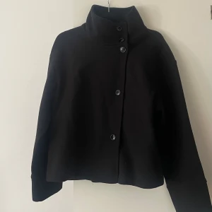 Svart jacka med hög krage - ginatricot  - Säljer en svart jacka med hög krage  Jackan har en loose passform.  perfekt för kyliga dagar. Stilren och enkel design som ger en cool vibe. Från ginatricot