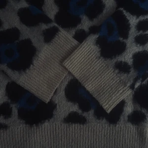 Leopardmönstrad stickad tröja Gina Tricot - Stickad tröja från Gina Tricot i beige med svart och blått leopardmönster. Tröjan har ribbade muddar vid ärmslut, nederkant och halsringning. Väldigt varm och mysig. 