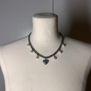 Halsband med pärlor och hjärta  - Handgjort kedjehalsband med pärlor. Kedjan är 7mm bred och 45cm lång. Allt i rostfritt stål förutom pärlorna. Fast pris satt efter materialkostnader och tillverkning. Köp gärna via köp nu, snabb leverans.