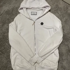 Philipp plein hoodie - Säljer nu min vita Philipp plein hoodie då jag har bytt stil. Köpt på NK Stockholm för ca 3500 på rabatt så givetvis äkta. Storlek M men passar även S. Inga skador eller defekter alls. Skriv vid fler frågor. Tags från NK medföljer.