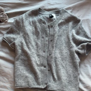 Grå stickad bolero med knappar -  Grå stickad bolero med knappar från H&M. Storlek XS och har använts några gånger men inga stora defekter.