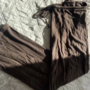 Bruna mjukisbyxor från Nelly M - Säljer ett par bruna mjukisbyxor från Nelly i storlek M. Byxorna har snörning i midjan och är gjorda i mjukt bomullsmaterial. Perfekta för chill dagar och har en loose passform med raka ben.