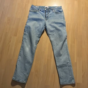 Jack & Jones ljusblå jeans Regular Clark - Ljusblå jeans från Jack & Jones, modell Regular Clark. Storlek 32 34. De har en rak passform och är tillverkade i ett slitstarkt denimtyg. Perfekta för en stilren look.