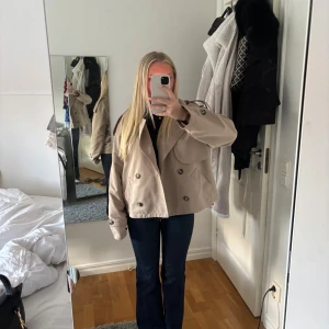 Beige kort trenchcoat  - Jättefin beige trenchcoat från Vero Moda i storlek M, till referens så är jag 1,60 lång. Kommer inte till användning lika mycket då jag har andra jag använder 🩷 skriv för fler funderingar eller bilder