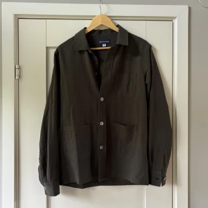 Mörkgrön overshirt - Helt ny olivgrön overshirt från ST studios. Nypris 1895kr säljer den nu för endast 699kr. Storlek S passar även M.