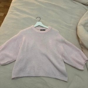 Ljusrosa stickad tröja Gina Tricot - Supermysig ljusrosa stickad tröja från Gina Tricot. Tröjan har en rund halsringning, breda ärmar och en loose passform. Perfekt för lager på lager och chill dagar. Mjuk och fluffig känsla, enkel att matcha med jeans eller kjol.