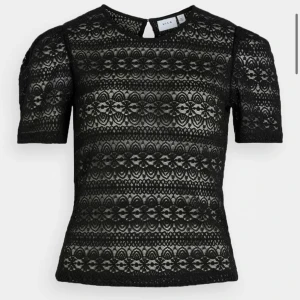 Svart spets från Vila - Säljer en svart tröja från Vila med korta puffärmar och vackert spetsmönster i blommig design. 