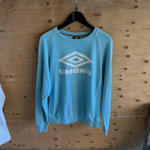 Umbro- Tröja, vintage  - Umbro- Tröja, sweatshirt, med tryck, vintage  -Material: 100% bomull  -Storlek: Small Mått- Längd: 62cm Axlar: 40cm Byst: 52cm Midja: 48cm Ärm: 49cm -Skick: Mycket bra, utan anmärkningar
