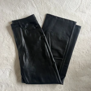 Svarta raka byxor i skinnimitation - Snygga svarta byxor i skinnimitation från veromoda. Kolla sista bild för storlek