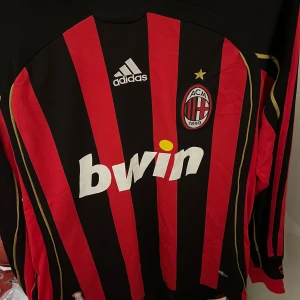 AC Milan långärmad matchtröja Adidas - Säljer en klassisk AC Milan långärmad fotbollströja från Adidas med röda och svarta vertikala ränder, gulddetaljer och klubbmärke på bröstet.  Priset går att diskutera vid snabb affär 