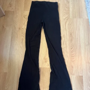 Svarta bootcut leggings - Svarta leggings med bootcut-snitt och hög midja. Mjukt och stretchigt material som sitter skönt på kroppen. Perfekta för en avslappnad och trendig look.