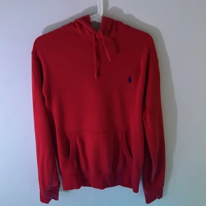 Röd hoodie från Polo Ralph Lauren - Riktigt snygg röd hoodie från Polo Ralph Lauren med klassisk blå broderad logga på bröstet. Den har inga defekter, pris kan diskuteras vid snabb affär.