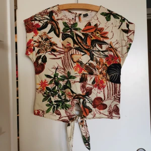 Ny Topp i bomull med tropiskt tryck - Ny Shein Topp i bomull med tropiskt tryck. Oanvänd, storlek XS (längd: 52 byst: 95)Bomull 100 %Pris online 99 sek