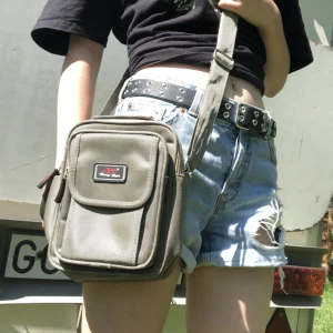 Axelremsväska - En axelremsväska köpt ifrån Spanien. Den kostade 50€ (cirka 500 kr). Den är sliten och är smutsig på insidan! Den har 5 fack.