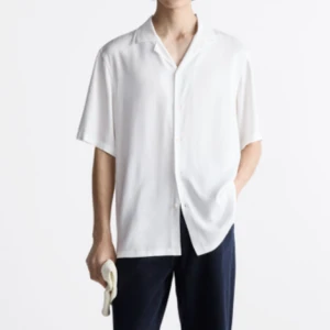 Skjorta från Zara - Oanvänd skjorta från Zara i viskos. Storlek L. Säljes pga för stor. Skrynklig pga legat vikt men annars inga fel. Superskönt material och snygg skjorta men tyvärr för stor. Jag är 187 cm 78 kg. Kan hämtas i Norrköping eller Västerås, eller skickad