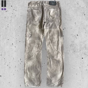 True religion jeans #697 - True Religion jeans i model Geno Super T 💜 Tag 31W 💜Midja (rakt över) 41cm 💜 Innerben 80cm 💜 Ytterben 106cm 💜 Benöppning 19cm 💜 Rip på rumpan, och små fläckar överallt 💜Våra mått blir W=32, L=31 💜 Men jämför alltid måtten💜697
