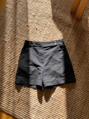 Kostymshorts - Kostymshorts med guldiga knappar från HM, köparen står för frakten. 