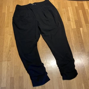 Finbyxor  - Ankelkorta med rynkade benslut  Dold knäppning och fickor fram