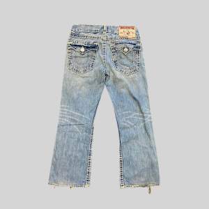 True religion jeans med liten utsvängning. • Storlek: W33 • Mått: Längd: 100cm • Midja: 43cm • Benöppning: 24,5cm • Innerbenslängd: 75cm • Lår: 20cm OBS: Hål på knäna och mindre distressing förekommer. Kolla innan du köper. 💙