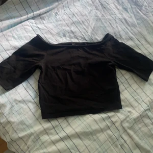 Svart croppad off-shoulder topp - Svart croppad off-shoulder topp från Monki. I storlek XS, passar XS-S.