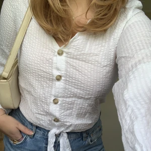 Blus med knytning - Vit långärmad blus med knappar och knytning längst ner 💘💘