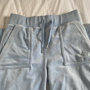 Juicy Couture byxor - Ett par ljusblåa juicy byxor. Köpta på plick och andvända ungefär 3 gånger. Har en liten fläck av en gång när jag råkade skrapa upp dom lite grann (kolla bild 3) men inget man tänker på om man inte kollar jätte nogrant. Startar ett bud på 500kr