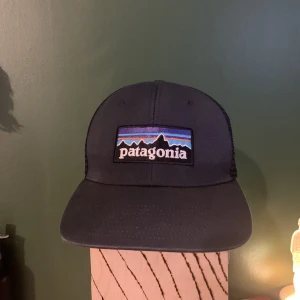 Patagonia keps - En mörkblå patagonia keps i använt skick men fortfarande existerande liksom. Onesize, unisex.