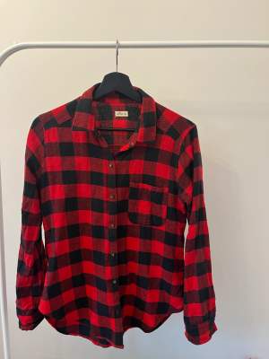 Röd flanellskjorta från Hollister i storlek S. En ficka på bröstet 