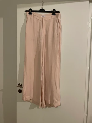 Rodbjer rosa byxor storlek large - Snygga lite vidare byxor från Rodbjer storlek L. Använda 1 gång.  Har blivit lite missfärgade ovanför byxfickan