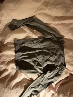 Grå Tröja - Tunt stickad grå tröja vet ej vart den är ifrån Två blåa färg fläckar på ärmarna 
