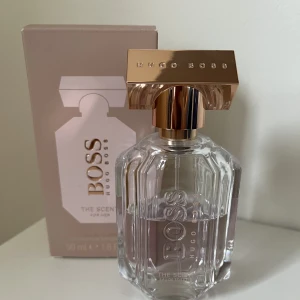 Hugo Boss The Scent for her EDT - Hugo Boss ”The scent for her” i EDT. 50 ml, med uppskattningsvis minst 30 ml kvar. Tror att just EDTn har utgått. Väldigt fräsh och lätt doft!   Toppnot: Rosépeppar & grön mandarin Hjärtnoter: Fresia & apelsinblomma Basnot: Kakaobönor