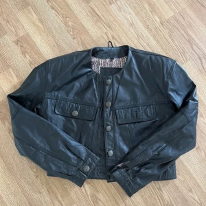 Vintage jacka - En croppad vintage skinnjacka i äkta skinn! Tyvärr saknas en knapp på ena bröstfickan. Storlek 38 men passar även 34-36:)