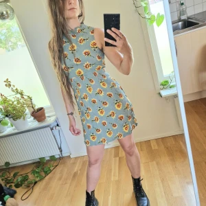 Klänning - Mintgrön klänning med solrosor. Aldrig använd 