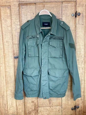 Field jacket för höst och vår - Armégrön jacka från Pull & Bear. Färgen stämmer m mittenbilden mest. Fint skick. Perfekt för vår, sommar och höst. Passar kille eller tjej. 