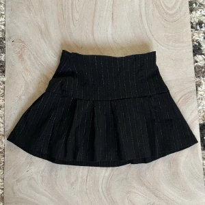 y2k minikjol  - En svart minikjol med glitterdetaljer. I bra skick med dragkedja på sidan. Stretchig. Längd 33,5cm