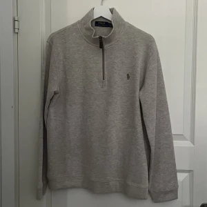Ralph Lauren Quarter Zip - Stickad Zip Tröja från Ralph Lauren. Färgen heter ”oatmeal” och en en variant på beige. TTS passform. Knappt använd så skick på 9.5/10